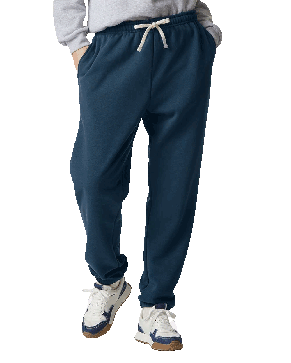 Navy blue sweatpants with drawstring waistband and cuffed ankles, paired with white and navy sneakers