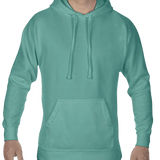 Front view of a man wearing a Comfort Colors Heavyweight Hoodie in Seafoam, showing the hoodie’s drawstring hood and front pocket. The model is smiling.