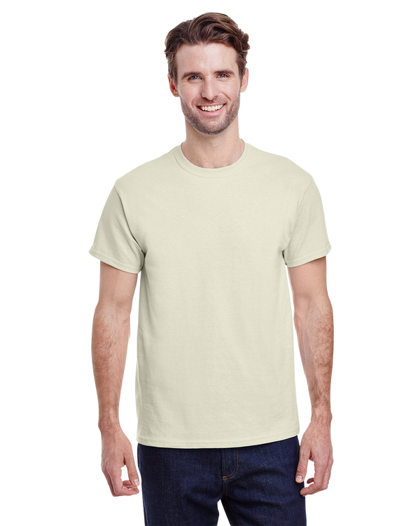 Man in a "Natural" colored Gildan Adult Heavy Cotton T-Shirt, standing with a relaxed posture and a friendly smile.