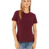 Front view of a blonde woman modeling a Bella + Canvas Ladies' Relaxed Jersey Short-Sleeve T-Shirt in the Maroon color, paired with light blue jeans.