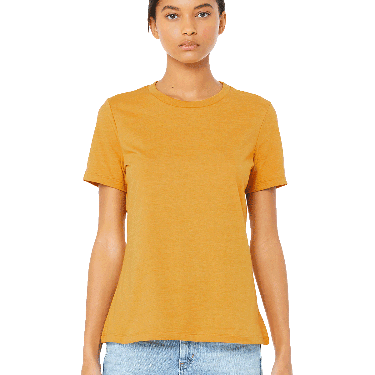 Woman wearing a Bella + Canvas Ladies' Relaxed Jersey Short-Sleeve T-Shirt in the Mustard color, standing with a neutral expression and light blue jeans.