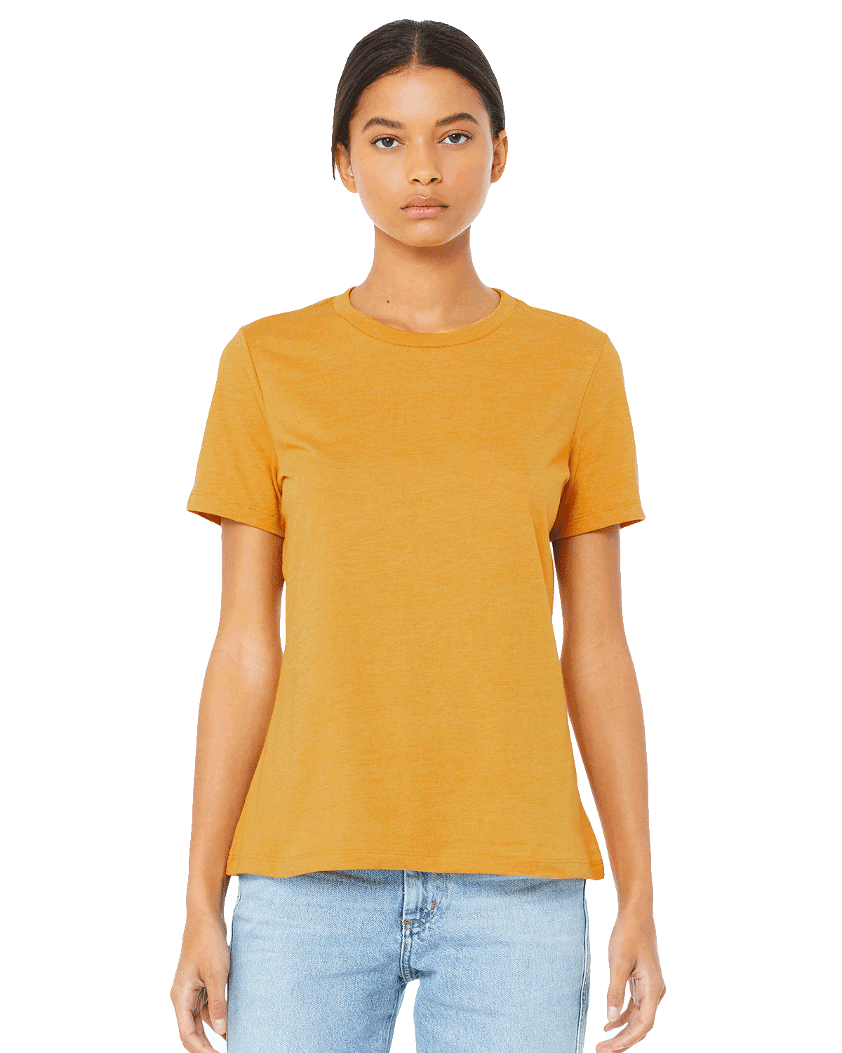 Woman wearing a Bella + Canvas Ladies' Relaxed Jersey Short-Sleeve T-Shirt in the Mustard color, standing with a neutral expression and light blue jeans.