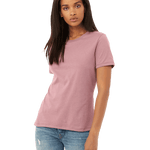 Front view of a woman modeling a Bella + Canvas Ladies' Relaxed Jersey Short-Sleeve T-Shirt in Orchid color, paired with light blue jeans.