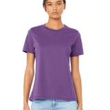 Woman wearing a Bella + Canvas Ladies' Relaxed Jersey Short-Sleeve T-Shirt in Royal Purple color, standing with a neutral expression and light blue jeans.