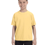 Smiling boy wearing a Comfort Colors Youth Midweight T-Shirt in "Butter" color, with hands by his sides.