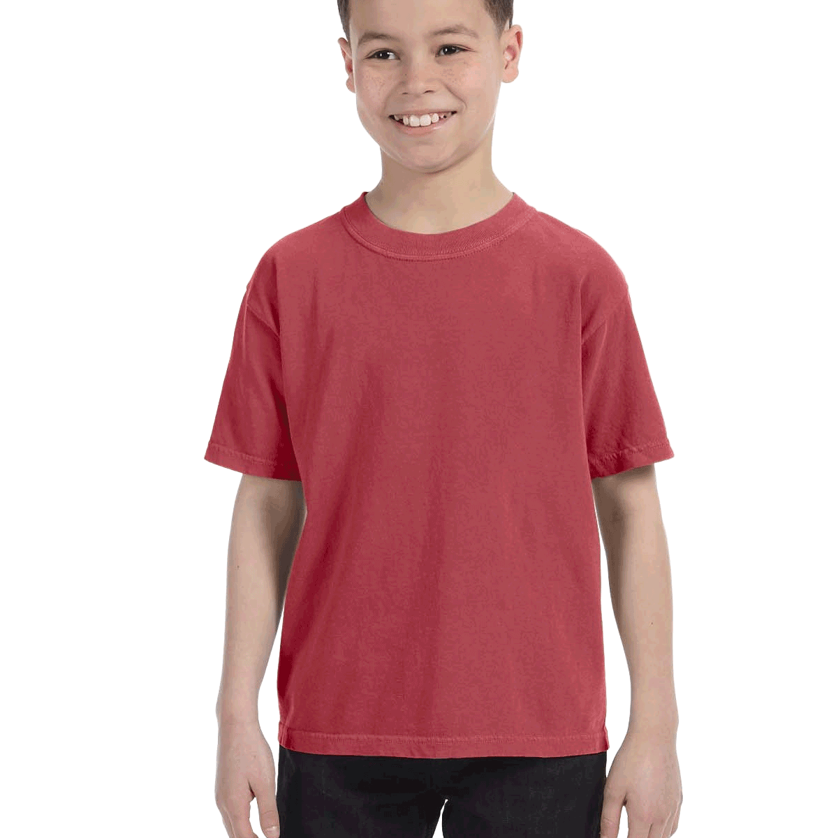 Young boy modeling a Comfort Colors Youth Midweight T-Shirt in "Crimson" color, standing with a cheerful expression.