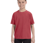 Young boy modeling a Comfort Colors Youth Midweight T-Shirt in "Crimson" color, standing with a cheerful expression.