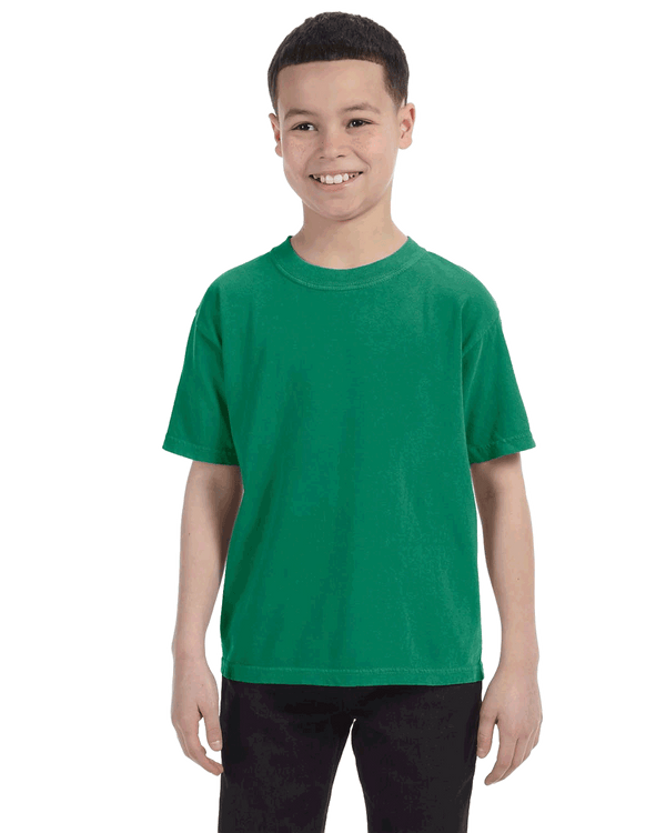 Comfort Colors Youth Midweight T-Shirt in "Grass" color worn by a smiling boy standing with hands relaxed.