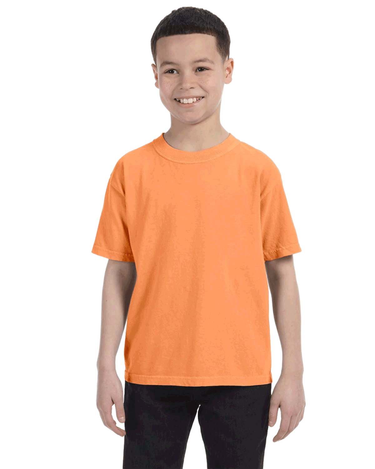 Young boy modeling a Comfort Colors Youth Midweight T-Shirt in "Melon" color, standing with a cheerful expression.