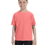 Child in a "Watermelon" colored Comfort Colors Youth Midweight T-Shirt, smiling while standing with hands relaxed by his sides.