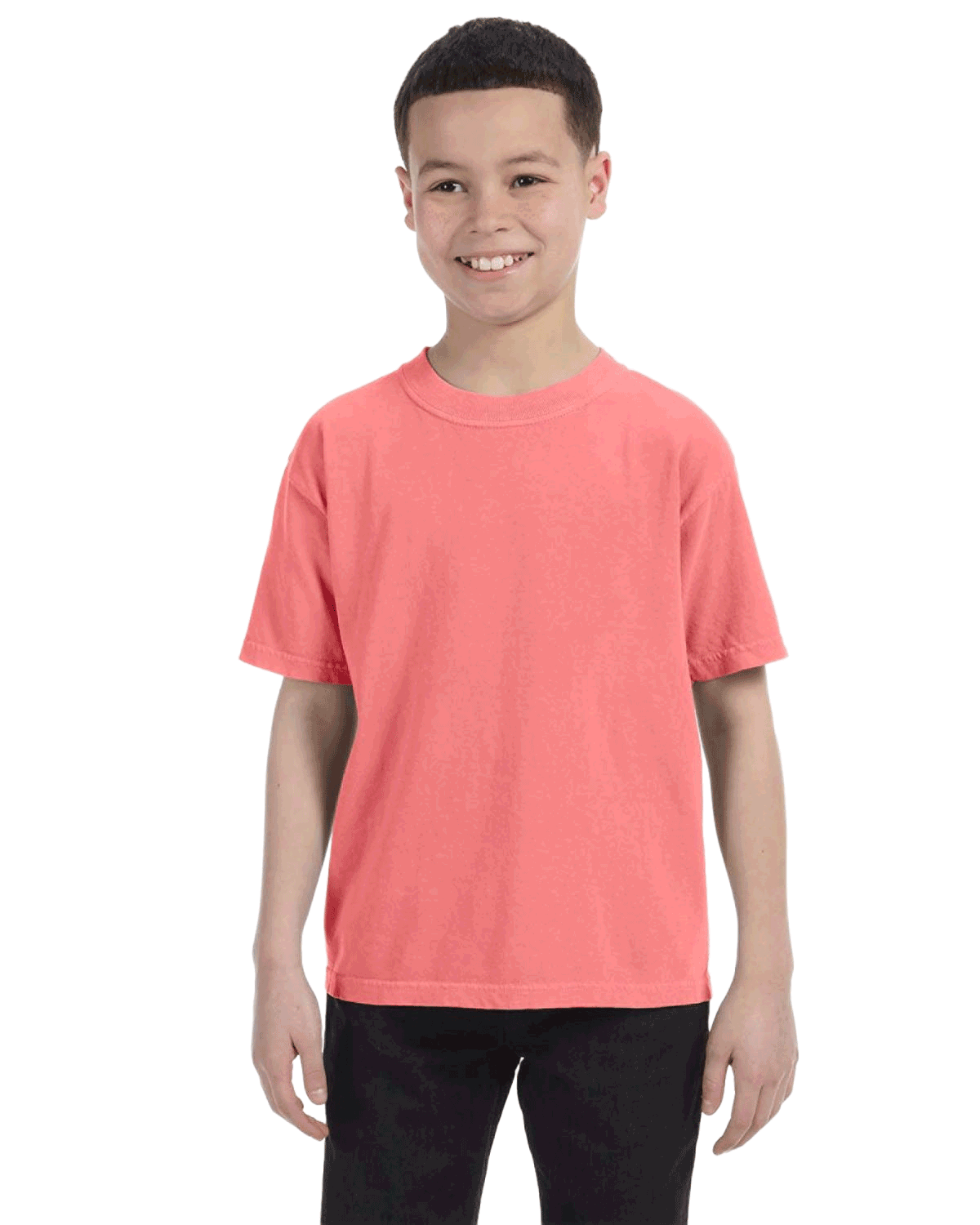 Child in a "Watermelon" colored Comfort Colors Youth Midweight T-Shirt, smiling while standing with hands relaxed by his sides.