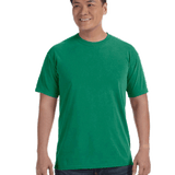 Man wearing a Comfort Colors Heavyweight T-Shirt in "Grass" color, smiling while standing with hands by his sides.