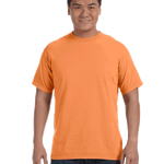 Man wearing a Comfort Colors Heavyweight T-Shirt in "Melon" color, smiling with hands relaxed by his sides.