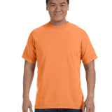 Man wearing a Comfort Colors Heavyweight T-Shirt in "Melon" color, smiling with hands relaxed by his sides.