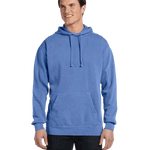 Man wearing a Comfort Colors Heavyweight Hoodie in Flo Blue, featuring a front pocket and relaxed fit. Model is smiling and standing with hands relaxed