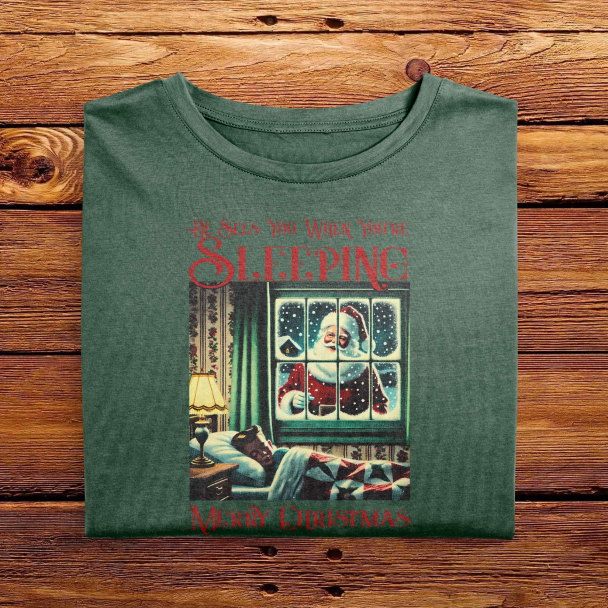 A Folded Moss Green Comfort Colors Tshirt featuring a vintage festive halftone design. The funny, yet creepy design has words that says He Sees You When Youre Sleeping, accompanied with a picture of Santa Clause standing outside of a kids bedroom window.