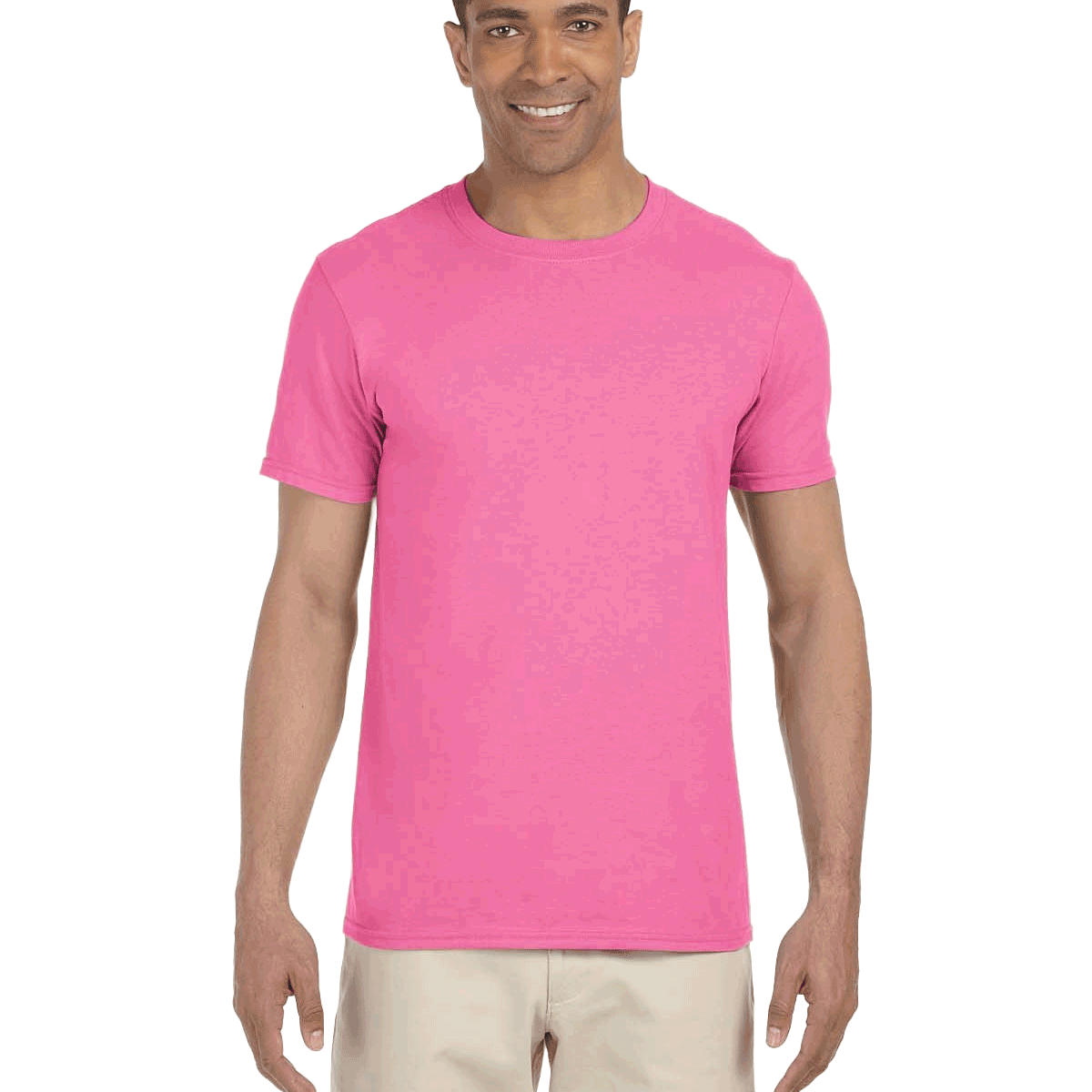 Man wearing a Gildan SoftStyle T-shirt in "Azalea" color, standing with a relaxed posture and smiling.