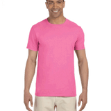 Man wearing a Gildan SoftStyle T-shirt in "Azalea" color, standing with a relaxed posture and smiling.