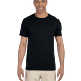 Man wearing a Gildan SoftStyle T-shirt in "Black" color, standing with a relaxed posture and smiling.