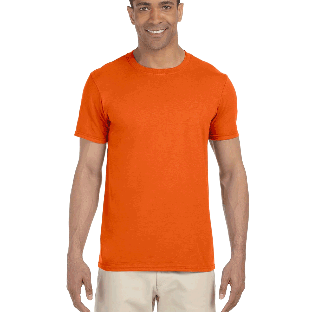 Man in a "Orange Sunset" colored Gildan SoftStyle T-shirt, standing with a relaxed posture and a friendly smile.