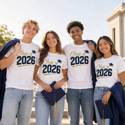Group of graduates wearing matching white Class of 2026 shirts and holding graduation caps