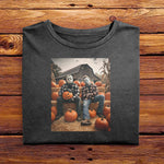 A Black folded Comfort Colors Tshirt, laying on a wooden table. The vintage design has Jason Vorhees from Friday the 13th, and Michael Meyers from Halloween, both in cozy flannels sitting together in a pumpkin patch. Jason is showing off his jack o lantern