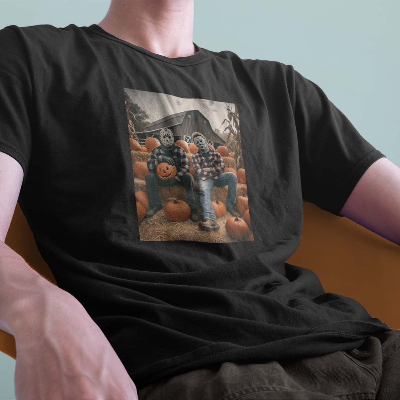 A model wearing a black Comfort Colors tshirt. The vintage design has Jason Vorhees from Friday the 13th, and Michael Meyers from Halloween, both in cozy flannels sitting together, arms crossed in a pumpkin patch. Jason is showing off his jack o lantern