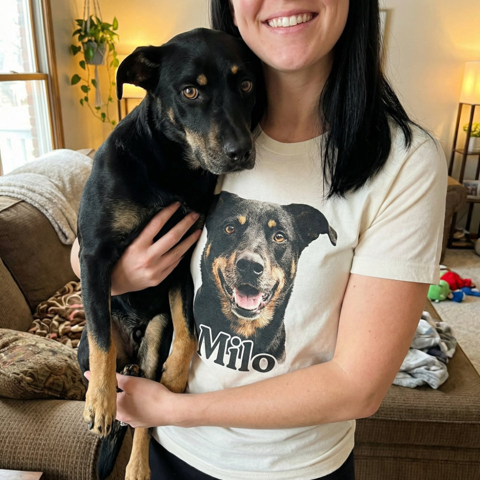 Person holding Milo the dog while wearing a custom T-shirt printed with Milo’s portrait
