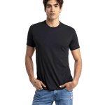 Man in a black Next Level Apparel Unisex CVC Crewneck T-Shirt, standing with hands in pockets and a relaxed posture.