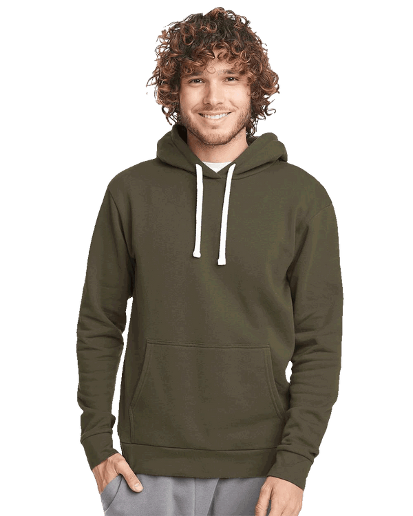 Man wearing olive green hoodie with front pocket and white drawstrings, smiling with hands in pockets