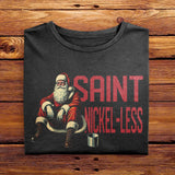 A Folded Comfort Colors Black Sweatshirt featuring a vintage design. The design features Santa Clause sitting down seemingly on the sidewalk, appearing to be struggling financially. The text beside him reads Saint Nickel-Less, poking fun at his misfortune