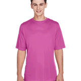 Boy wearing a Team 365 Men's Zone Performance T-Shirt in "Sport Charity Pink" color, standing with a relaxed posture and smiling.