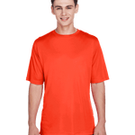 Boy in a "Sport Orange" Team 365 Men's Zone Performance T-Shirt, standing with a relaxed posture and a cheerful expression.