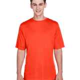 Boy in a "Sport Orange" Team 365 Men's Zone Performance T-Shirt, standing with a relaxed posture and a cheerful expression.