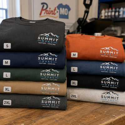 Summit HVAC company logo shirts in multiple colors and sizes stacked in the Print-MO shop