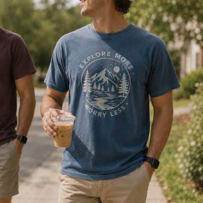 Man wearing a blue custom T-shirt with outdoor Explore More mountain graphic